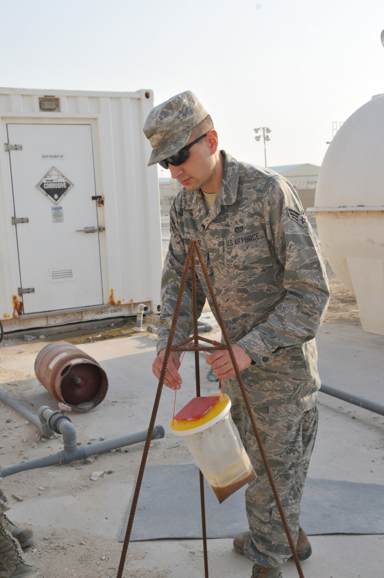Senior Airman Jonathan McDonald, 379th Expeditionary Civil Engineer Squadron pest management technician, checks a fly trap Feb. 8 at Al Udeid Air Base, Qatar. Fly traps are placed outside each dining facility to control fly pestilence. (U.S. Air Force photo by Tech. Sgt. Terrica Y. Jones/Released)