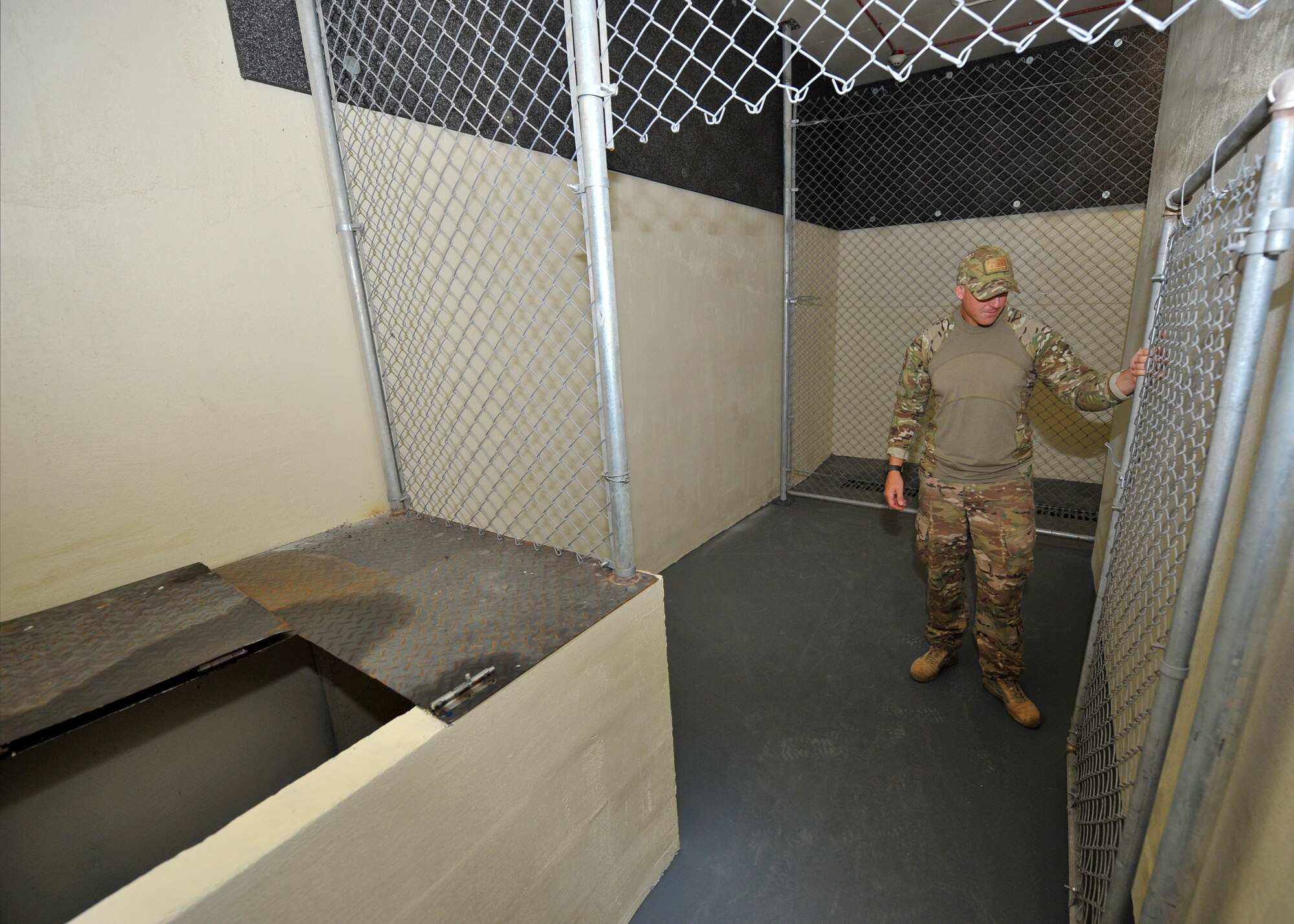 Royal Australian Air Force Leading Aircraftman Kevin Martins, Combat Support Unit 14 military working dog handler and trainer attached to the 380th Expeditionary Security Forces Squadron MWD Section, inspects a kennel in the newly constructed K9 compound at an undisclosed location in Southwest Asia, Jan. 26, 2016. The kennels are approximately 160 percent larger than those previous utilized and include a house for military working dogs to rest and relax. (U.S. Air Force photo by Staff Sgt. Kentavist P. Brackin/released)
