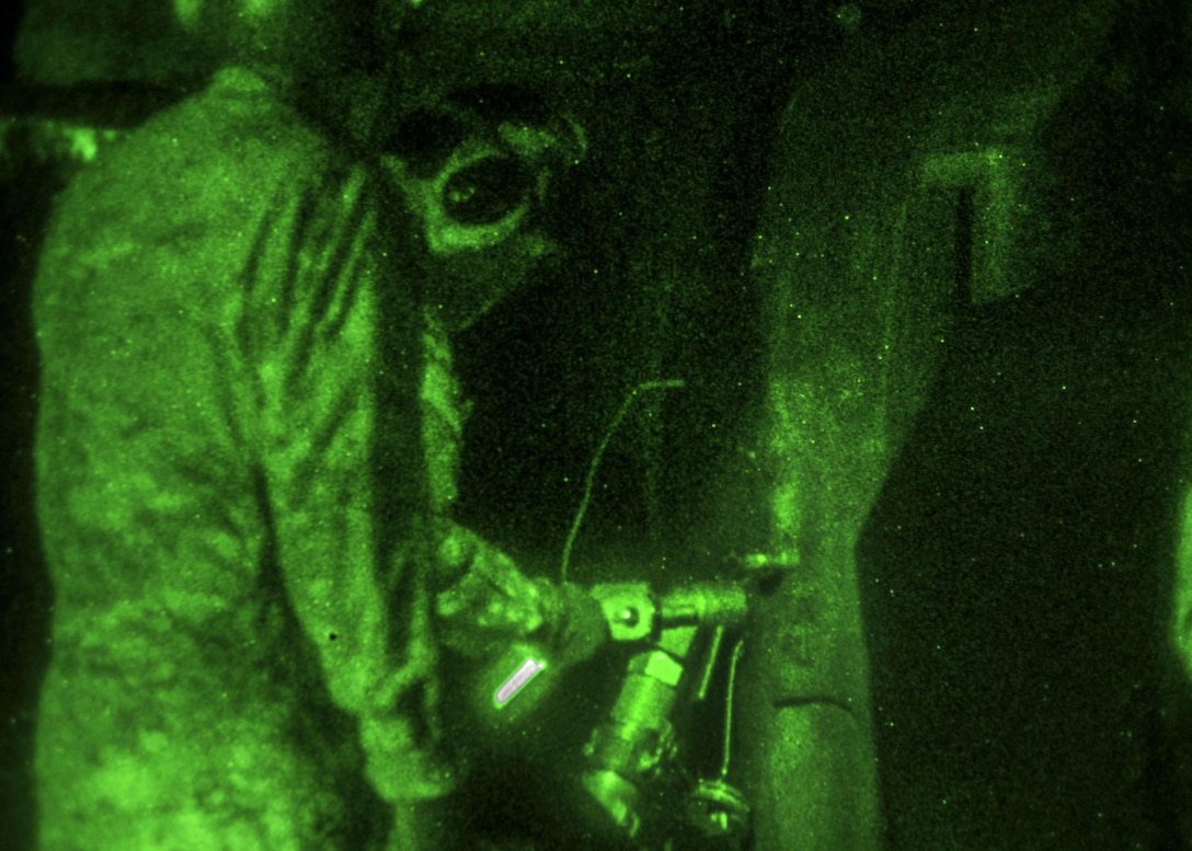 As seen through a night-vision device, a soldier pumps fuel into an OH-58 Kiowa Warrior helicopter at the forward arming and refueling point on Marine Corps Outlying Field Atlantic, N.C., Feb. 8, 2016. Army photo by Staff Sgt. Christopher Freeman