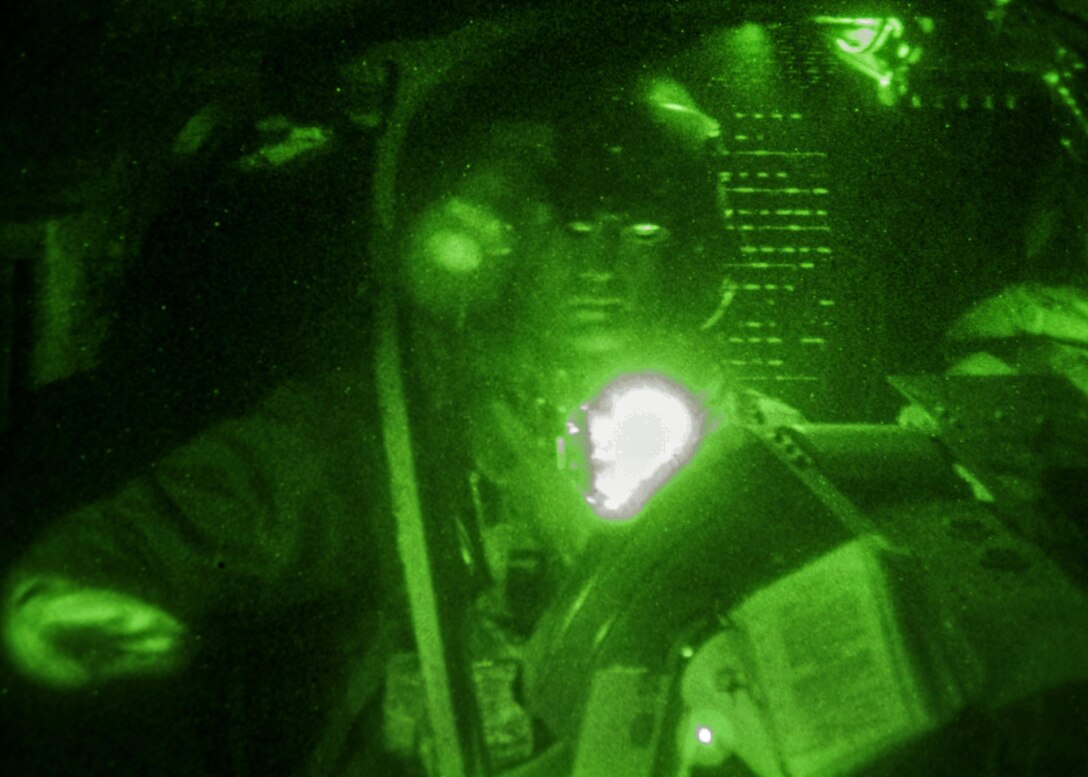 As seen through a night-vision device, a pilot gives the signal to stop pumping fuel into his OH-58 Kiowa Warrior helicopter at the forward arming and refueling point on Marine Corps Outlying Field Atlantic, N.C., Feb. 8, 2016. Army photo by Staff Sgt. Christopher Freeman