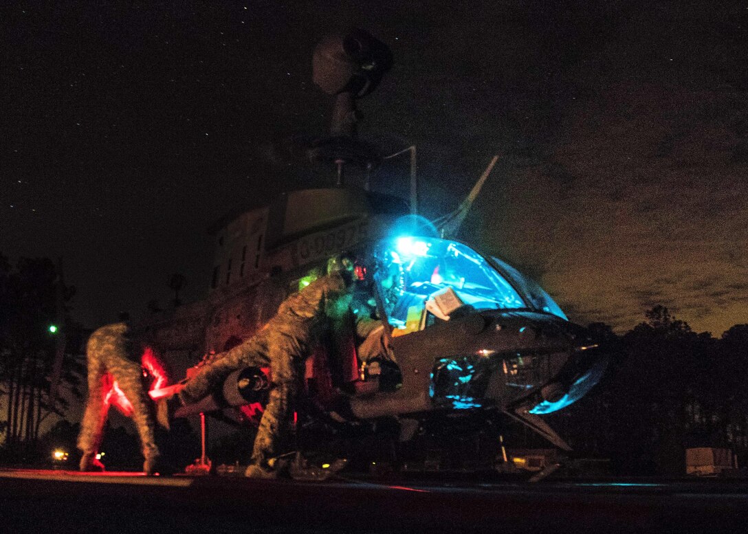 Fuel and ammunition is provided to an OH-58 Kiowa Warrior helicopter before a night live-fire exercise on Marine Corps Outlying Field Atlantic, N.C., Feb. 8, 2016. The soldiers and pilots are assigned to the 82nd Airborne Division’s 17th Cavalry Regiment, 82nd Combat Aviation Brigade. Army photo by Staff Sgt. Christopher Freeman