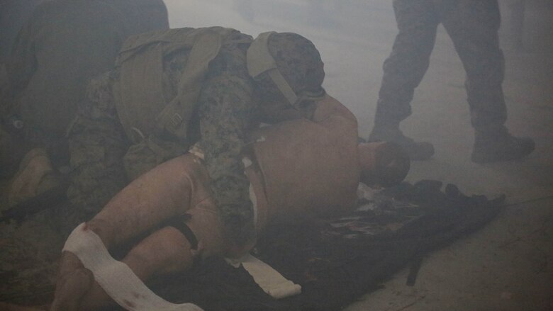 U.S. Navy Seaman Justin Phares, a hospitalman with 2nd Medical Battalion, treats a casualty during a tactical combat casualty care exercise at Marine Corps Base Camp Lejeune, N.C., Feb. 12, 2016. Sailors were challenged by a chaotic environment of smoke and loud, sporadic noises.