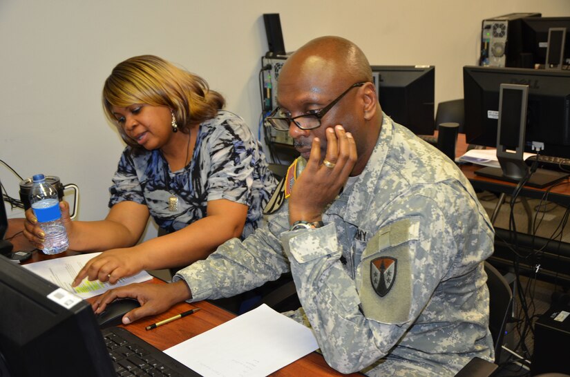 Shawn Willie, contracting specialist with the United States Army Corps of Engineers Huntsville Center, coaches team leader Lt. Col. Ronald Clark with the 917th Contracting Battalion out of San Antonio, on the final steps of a contract closeout. Select Soldiers of the Army Reserve Sustainment Command’s 915th and 917th Contracting Battalions are partnering with USACE during their monthly battle assembly to teach and train Soldiers on contracting actions to help build their skillset.  