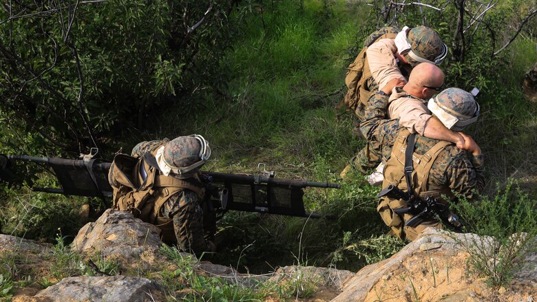 A Marine aid and litter team retrieves a simulated down pilot during a tactical recovery of aircraft and personnel, or TRAP, training scenario at Camp Pendleton, Calif., Feb. 10, 2016. In preparation for their upcoming deployment with the 31st Marine Expeditionary Unit, the TRAP scenario offers the Marines of Weapons Company, 2nd Battaion, 4th Marine Regiment, 1st Marine Divison, a secondary skillset in additon to their own primary duties, refining their ability to efficiently conduct a recovery mission. (U.S. Marine Corps photo by Lance Cpl. Devan K. Gowans/Released)