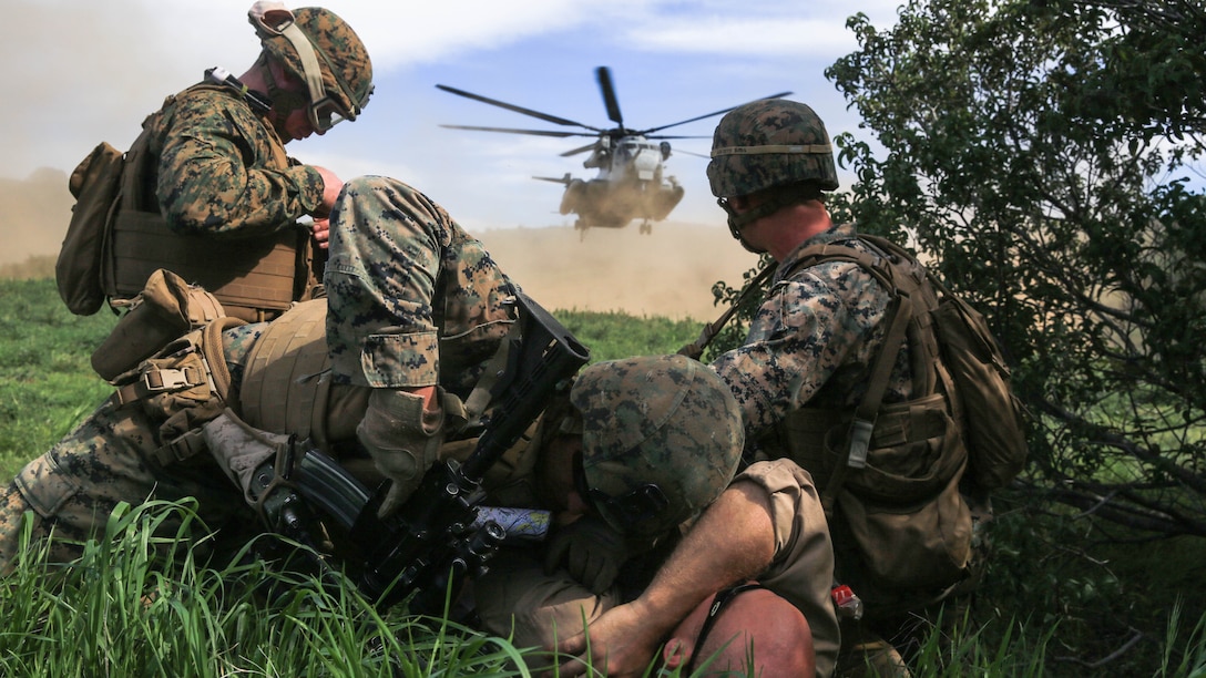 Marines protect a simulated injured person from the rotor wash of a CH-53E Super Stallion transport helicopter during a tactical recovery of aircraft and personnel, or TRAP, training scenario at Camp Pendleton, Feb. 10, 2016. TRAP is used to tactically recover personnel, equipment or aircraft by inserting the recovery force to the objective location. The Marines are with Weapons Company, 2nd Battalion, 4th Marine Regiment, 1st Marine Division. (U.S. Marine Corps photo by Lance Cpl. Devan K. Gowans/Released)