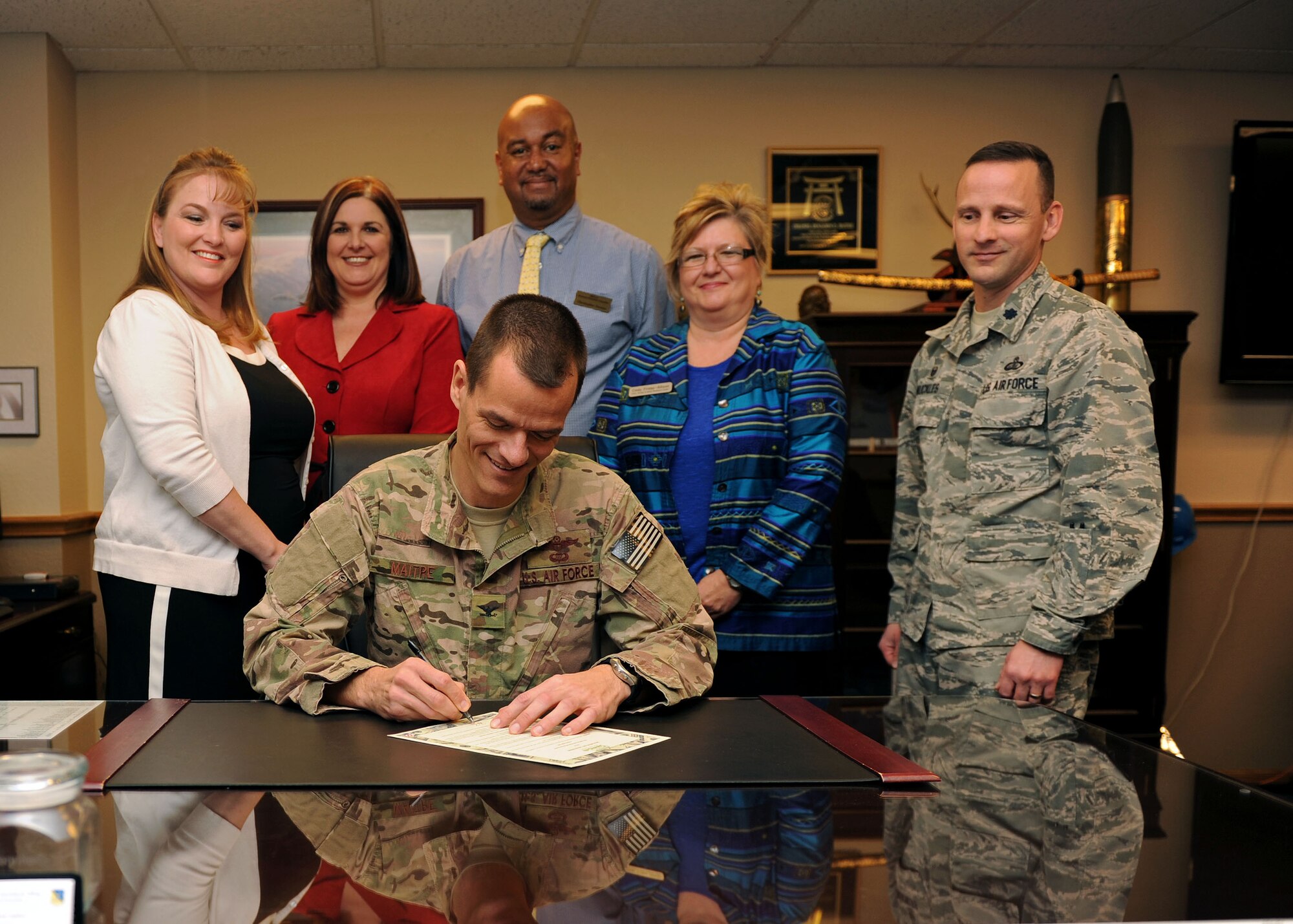 Col. Ben Maitre, 27th Special Operations Wing commander, signs a proclamation designating Feb. 22 through Feb. 27 as Military Saves Week, with members of the 27th Special Operations Force Support Squadron’s Airman & Family Readiness Center financial planning team looking on, Feb. 11, 2016 at Cannon Air Force Base, N.M. Military Saves Week provides an opportunity for members of the military community to come together with federal, state and local resources to focus on the financial readiness of military members and their families, helping them to reduce debt and save their money. (U.S. Air Force photo/Staff Sgt. Whitney Amstutz)