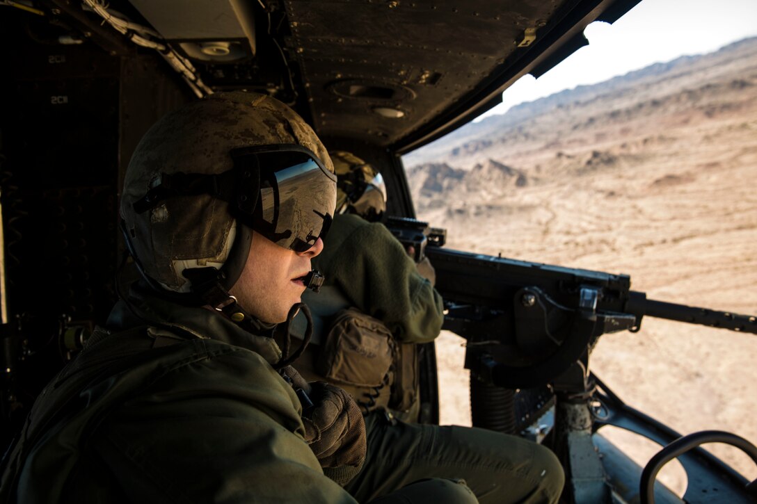 Sgt. Benjamin Hebert, a crew chief with Marine Light Attack Helicopter Squadron 469 (HMLA-469), based out of Marine Corps Air Station Camp Pendleton, Calif., observes and verifies hits as Sgt. Daniel O’Niel, an aerial observer, fires a GAU-21 machine gun from a UH-1Y “Venom,” during exercise “Scorpion Fire,” at the Chocolate Mountain Aerial Gunnery Range, Friday, Feb. 5, 2016.