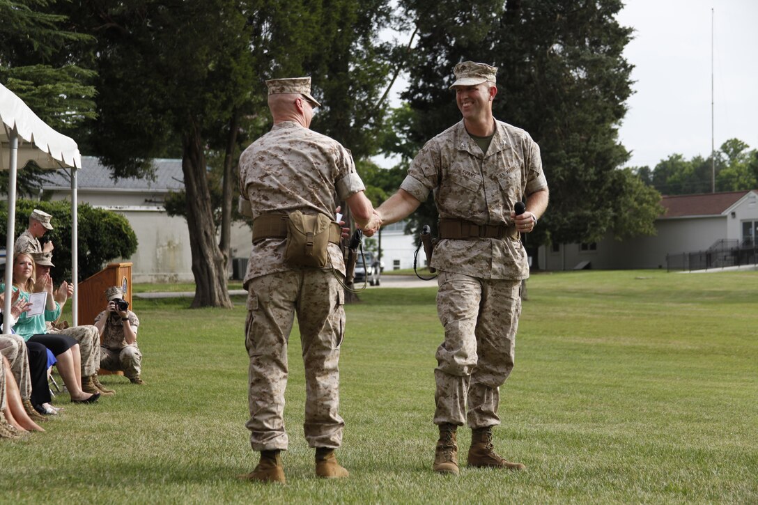 U.S. Marine Col. James M. Bright, outgoing regimental commanding officer, Marine Corps Security Force Regiment, left, shakes the hand of Col. Jown W. Evans, incoming regimental commanding officer, right, as he prepares to speak to invited guests during the Marine Corps Security Force Regiment change of command aboard Naval Weapons Station Yorktown, Va., June 19, 2015. The Marine Corps Security Force Regiment serves as support for anti-terrorist operations worldwide and the security of high value nuclear assets. (U.S. Marine Corps photo by Sgt. Esdras Ruano/Released)