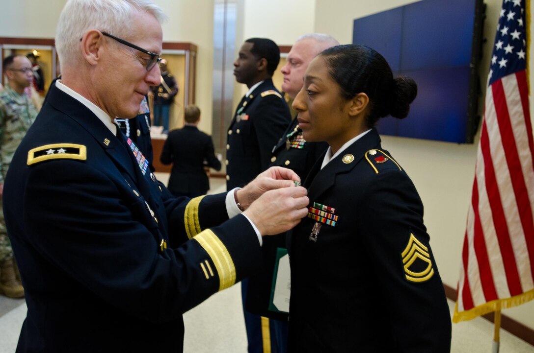 Maj. Gen. Peter S. Lennon, Deputy Commanding General (Support), U.S. Army Reserve, presents Sgt. 1st Class JaDrian Whitfield, course instructor assigned to the 80th Training Command, with an Army Commendation Award for her selection as the U.S. Army Reserve Instructor of the Year (noncommissioned officer), at USARC headquarters, Feb. 11, 2016. Whitfield was honored alongside winners from the officer and warrant officer category, in the first USARC hosted Instructor of the Year Ceremony held here. (U.S. Army Reserve photo by Brian Godette, USARC Public Affairs)