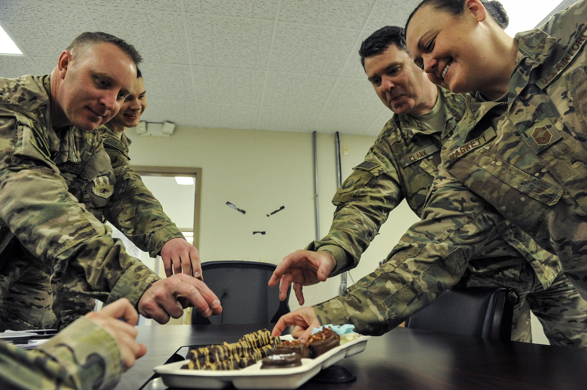 From left to right, Lt. Col. Johnathan Cartwright, 1st Lt. Amanda Urban, Col. William Clark and Chief Master Sgt. Shelley Haskett, all from the 455th Expeditionary Mission Support Group, try a group of confections made by Dan Johnson, the 455th EMSG contract augmentation program manager and deployed treat maker, at Bagram Airfield, Afghanistan, on Feb. 16, 2016. Johnson envisions and creates culinary confections from care packages and gives them to service members around the base. (U.S. Air Force photo/Tech. Sgt. Nicholas Rau)