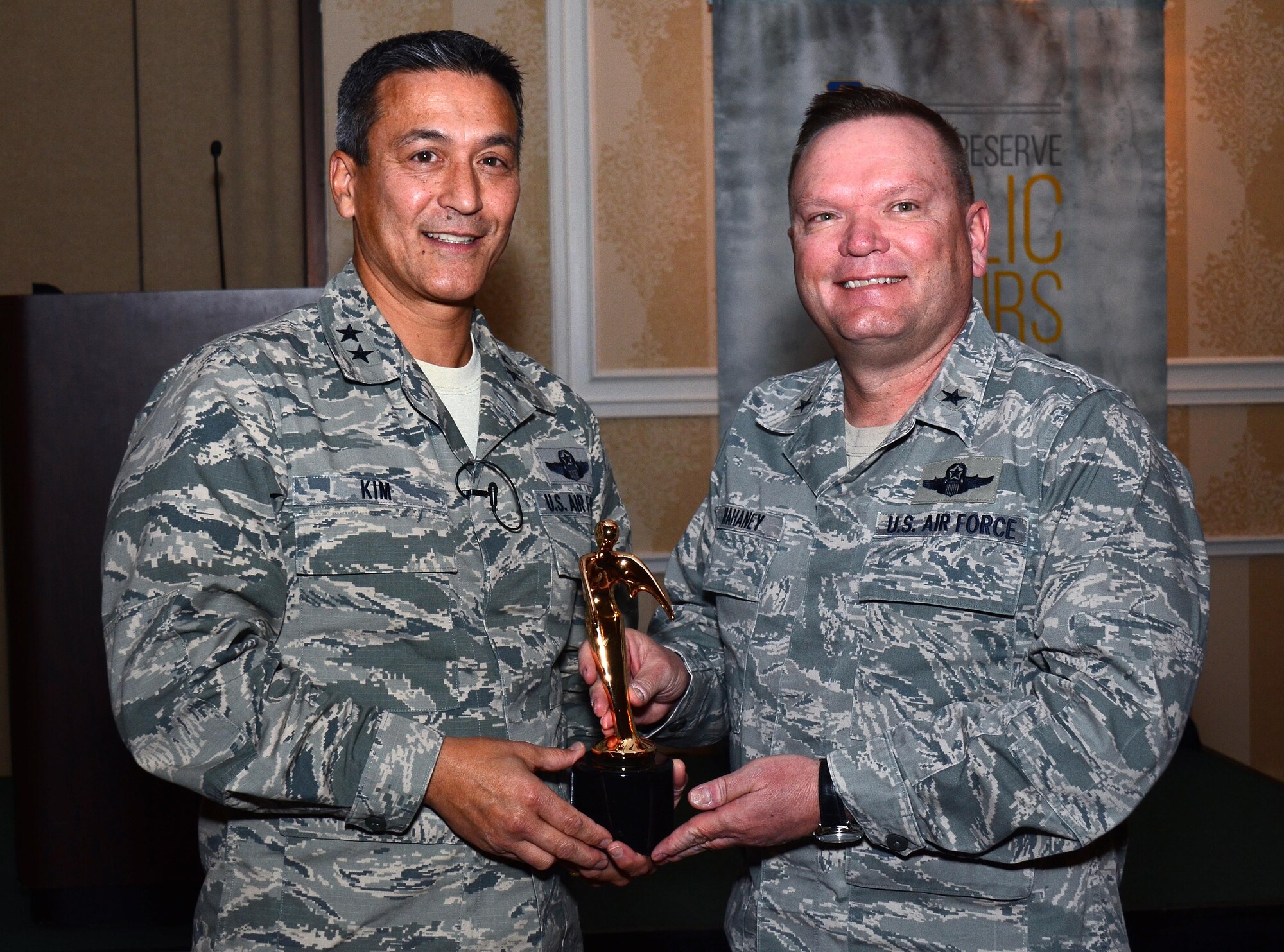 Maj. Gen. Michael Kim, mobilization assistant to the Commander, Air Force Reserve Command, presents the Public Affairs Champion award to Brig. Gen. Samuel "Bo" Mahaney, Air Reserve Personnel Center commander, at the Public Affairs Leadership Symposium held Feb. 9, 2016, in Marietta, Ga. This award recognizes commanders who are highly supportive and involved in the Public Affairs career field. (U.S. Air Force photo/Don Peek)