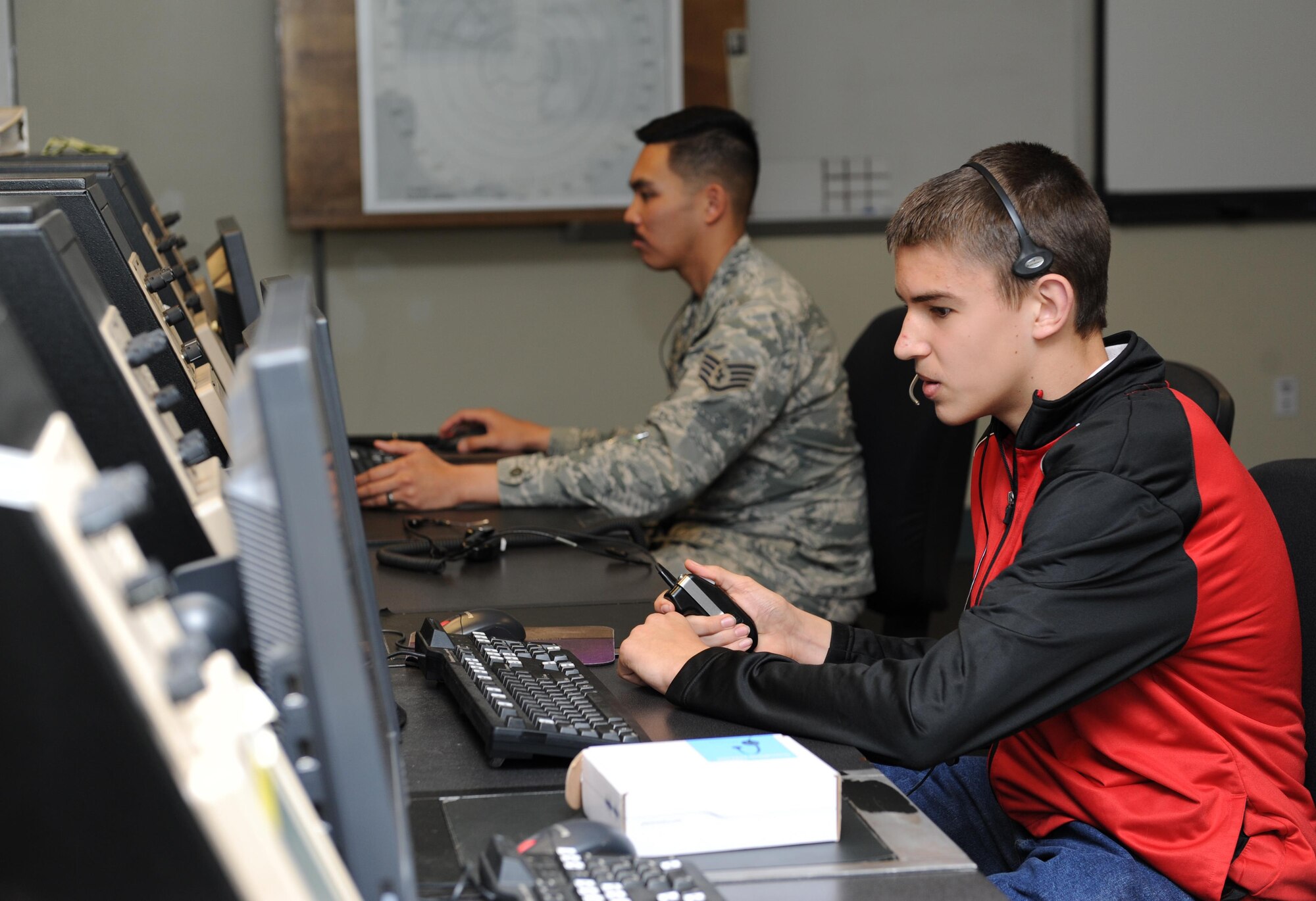 Billy Mays, son of William Mays, 81st Training Wing inspector general inspection planner, operates an air traffic control radio with the assistance of Staff Sgt. Michael Villamor, 334th Training Squadron air traffic control instructor, at Cody Hall during Biloxi Career Exploration Day Feb. 11, 2016, Keesler Air Force Base, Miss. The school-aged children also toured the 335th TRS weather facility, 81st Security Forces Squadron canine facility, 53rd Weather Reconnaissance Squadron and the Keesler Fire Department. (U.S. Air Force photo by Kemberly Groue)