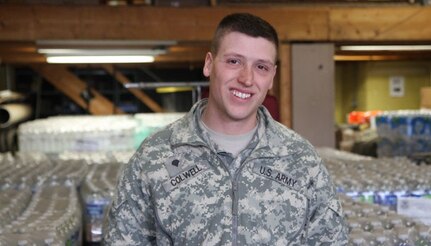 Spc. Charles Colwell stands outside his assigned distribution site, Fire Station 1, Flint, Michigan, Feb. 12, 2016. Colwell played an instrumental role in providing assistance to a Flint resident last week.