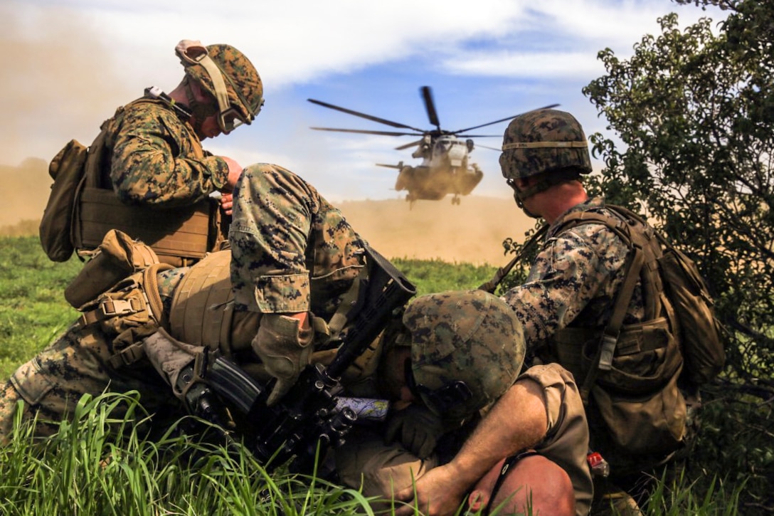 Marines protect a simulated injured person from the rotor wash of a CH-53E Super Stallion helicopter during a tactical recovery of aircraft and personnel training scenario on Camp Pendleton, Calif., Feb. 10, 2016. The Marines are with Weapons Company, 2nd Battalion, 4th Marine Regiment. Marine Corps photo by Lance Cpl. Devan K. Gowans