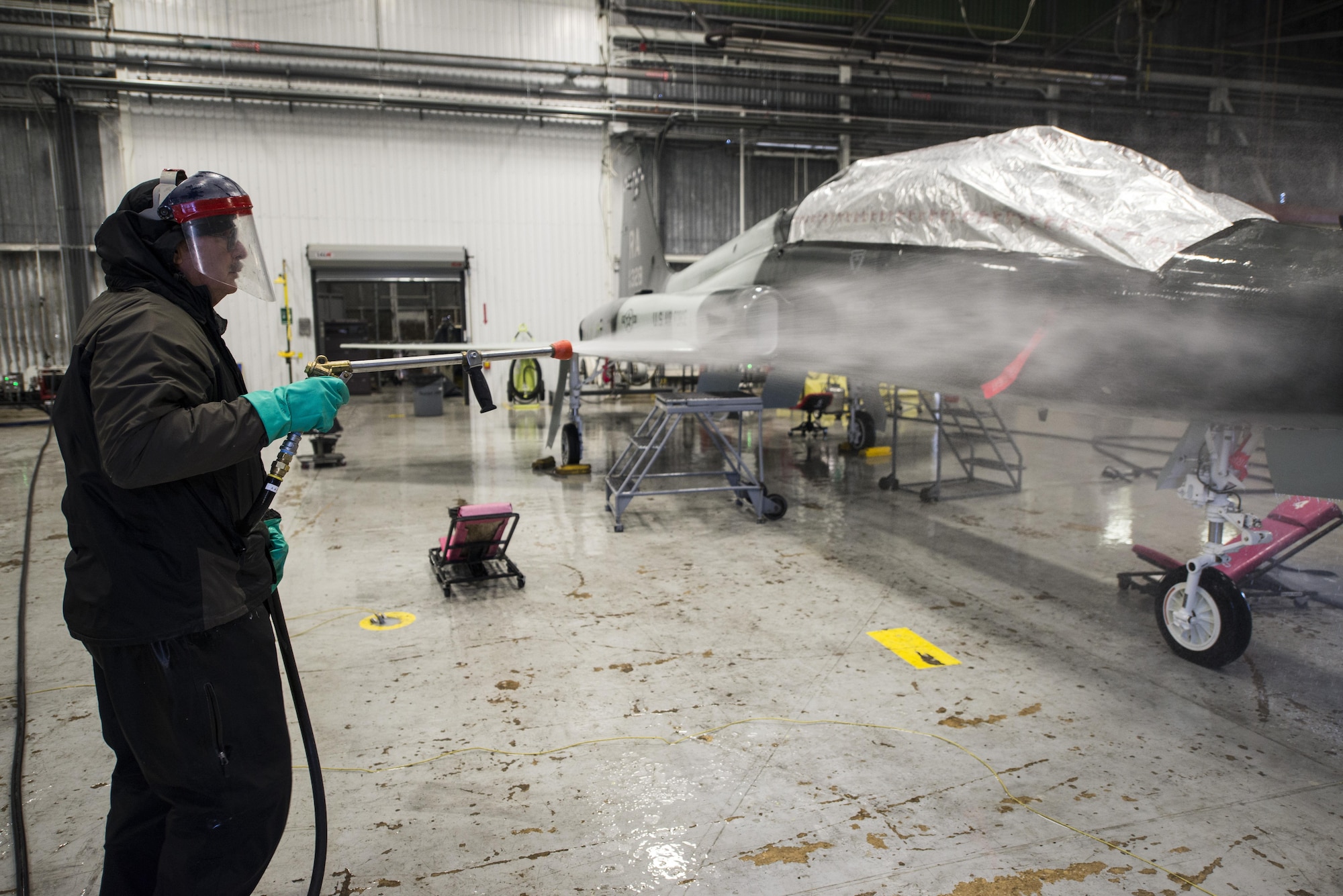 Rudy Olivarez, 12th Flying Training Wing Maintenance Directorate, rinses a T-38 Talon Feb. 2 at the new wash rack inside Hangar 42 at Joint Base San Antonio-Randolph. The water-recycling system conserves water and prevents contaminants from entering the San Antonio River Authority wastewater system.
