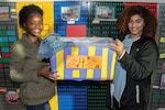 Bryttney London (left), Keystone Club president, and Darian Elkins, Keystone Club secretary, place a Teens for Jeans donation box at the Joint Base San Antonio Youth Center Feb. 3. Teens for Jeans is an annual worldwide effort to provide jeans for children 18 years of age and under who are in homeless shelters.