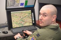 Capt. Andrew Byrd, 451st Flying Training Squadron combat systems operator flight commander, demonstrates the T-28 computer simulator he created.Up to seven scenarios allow student CSOs to experience their role while orbiting a target area in support of realistic-looking friendly troops the CSO sees on a monitor.  