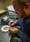 Denny Shaffer, 2nd Dental Squadron laboratory technician, stains a crown at Barksdale Air Force Base, La., Feb. 12, 2016. Shaffer used a variety of pigments to match the stain to the patients natural tooth color. (U.S. Air Force photo/Airman 1st Class Mozer O. Da Cunha)