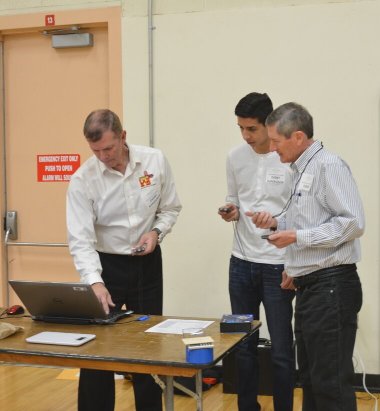 ALBUQUERQUE, N.M. – Event judge Reginald Bourgeois, left, and two other judges record the flight time of a student’s plane in the Wright Stuff event, Jan. 30, 2016.
