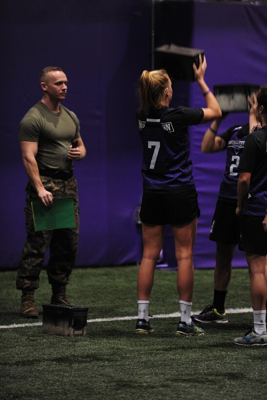 Capt. Frank Swan, officer selection officer for Recruiting Station Chicago, monitors collegiate athletes as they press ammo cans, during their training exercise at Northwestern University’s Nicolette Indoor Training Facility in Evanston, Ill., Feb. 16, 2016. The athletes were learning Marine Corps combat readiness fundamentals while receiving mid-season physical conditioning training. 
