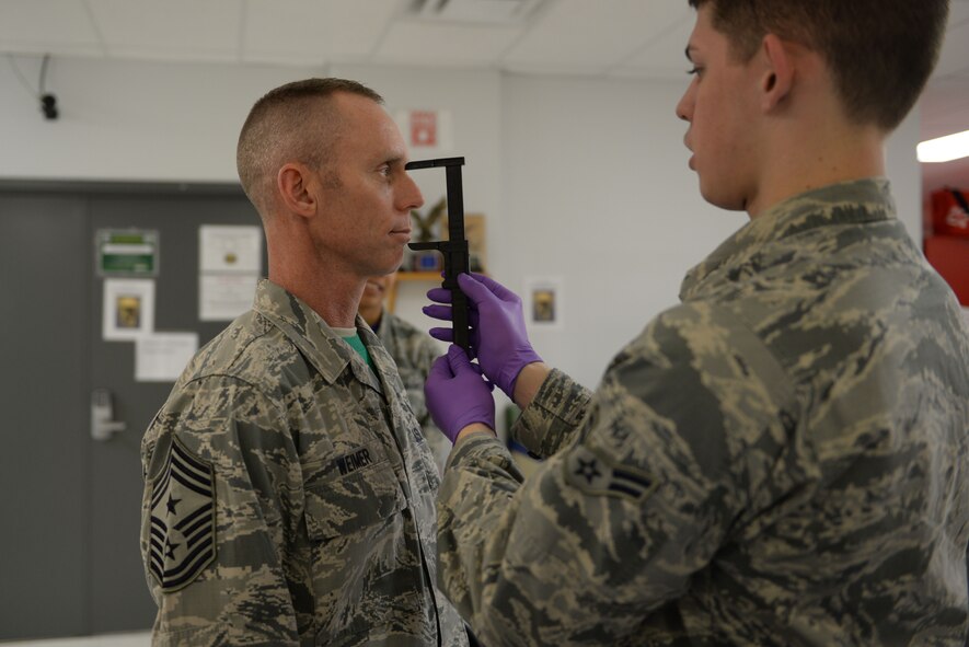 Airman 1st Class Karl Ochsenbein, an aircrew flight equipment journeyman assigned to the 5th Operations Support Squadron, measures Chief Master Sgt. Geoff Weimer’s, 5th Bomb Wing command chief, face for the appropriate sized helmet at Minot Air Force Base, N.D., Feb. 12, 2016. Properly sized masks ensure Aircrew will receive adequate oxygen to carry out their mission. (U.S. Air Force photo/Airman 1st Class Jessica Weissman)