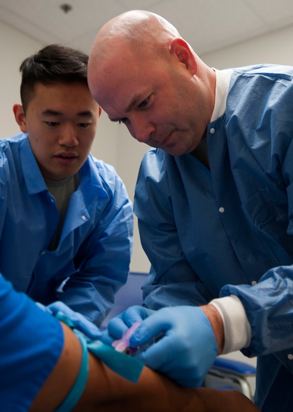 U.S. Air Force Chief Master Sgt. Aaron Bennett, 7th Bomb Wing command chief, and Airman 1st Class Woo Kim, 7th Medical Support Squadron laboratory services technician, perform a blood draw during “Teach the Chief” at the 7th Medical Group Feb. 9, 2016, at Dyess Air Force Base, Texas. As the command chief, Bennett is responsible for the professional growth, training, health, morale and welfare of the enlisted Airmen of the 7th BW. These visits help him get to know Airmen personally and professionally. (U.S. Air Force photo by Airman 1st Class Katherine Miller/Released)