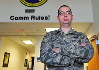 Staff Sgt. John Untz, 325th Communications Squadron radio frequency transmissions systems technician, stands in front of the 325th CS logo in building 817 Feb. 17. Untz was selected to be the 325th CS unsung hero. (U.S. Air Force photo by Senior Airman Dustin Mullen/Released)