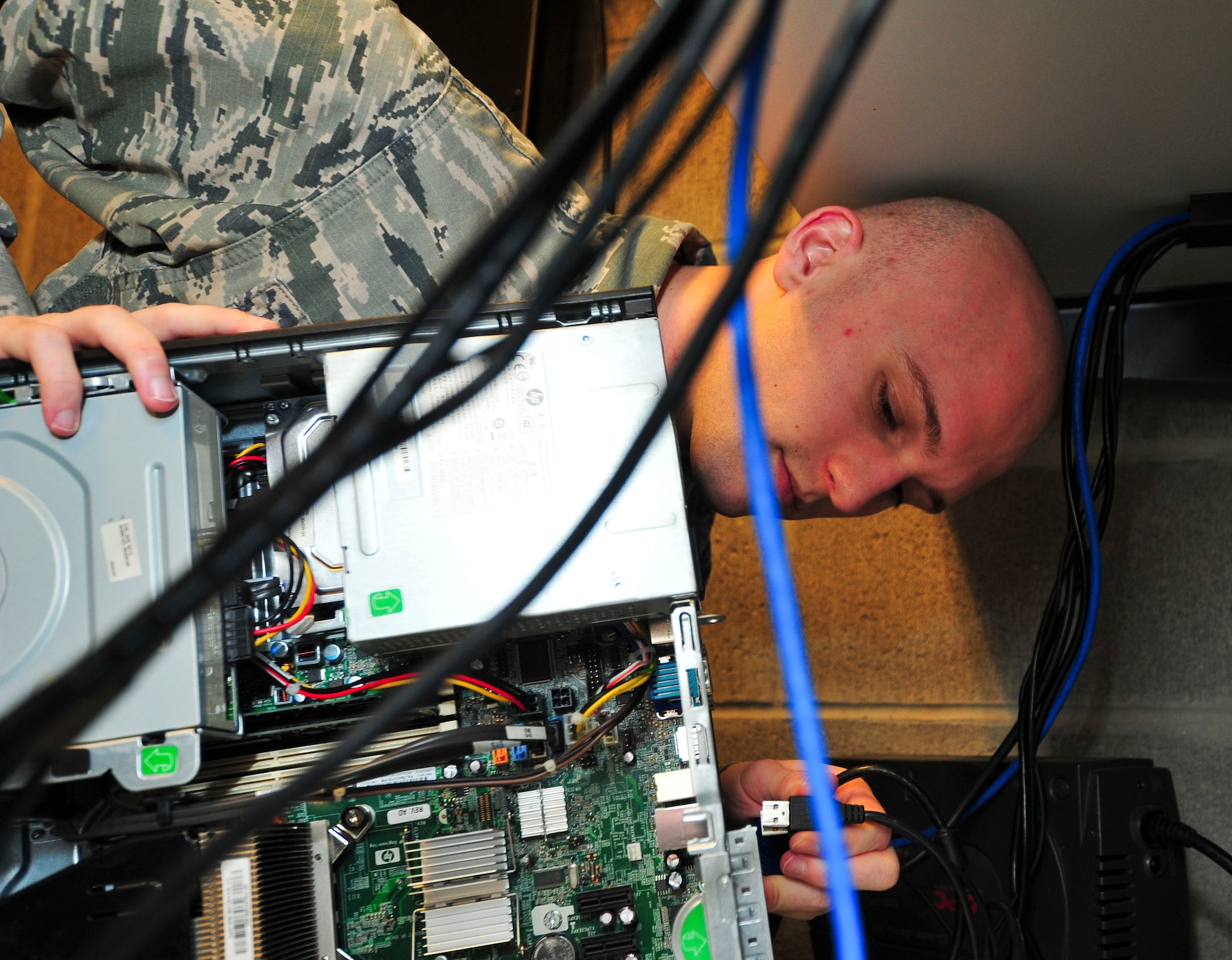 Airman 1st Class Tyler Crowson, 325th Communication Squadron client systems technician, plugs in a cable as he troubleshoots a desktop computer Feb. 11 at the 325th CS annex. As a CST, Crowson is tasked with fixing computers when problems arise. (U.S. Air Force photo by Senior Airman Dustin Mullen/Released)