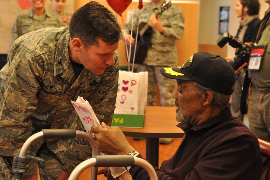 Col. John Devillier, 88th Air Base Wing commander, talks with Adolphus Alphabet, an Army veteran, and gives him a Valentine’s Day bag of ‘thank you’ cards from local school children. (U.S. Air Force photo/Gina Marie Giardina)