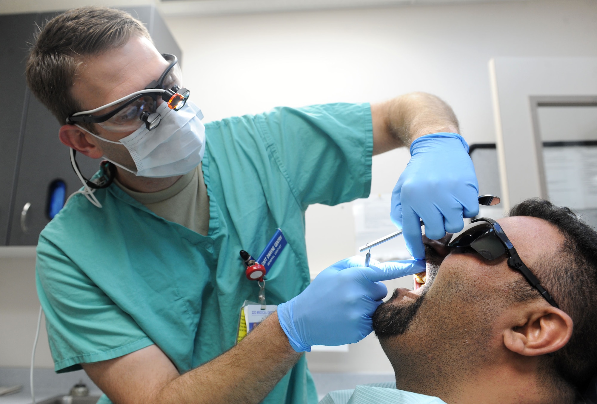 Capt. Dwayne Gentry, 22nd Aerospace Medicine Squadron general dentist, performs a check-up on Hasanain Abdulameer, an Iraqi national, Feb. 10, 2016, at McConnell Air Force Base, Kan. The Iraqi national is attending an aircraft training class under Department of Defense sponsorship and the pain distracted from his training. (U.S. Air Force photo/Senior Airman David Bernal Del Agua)