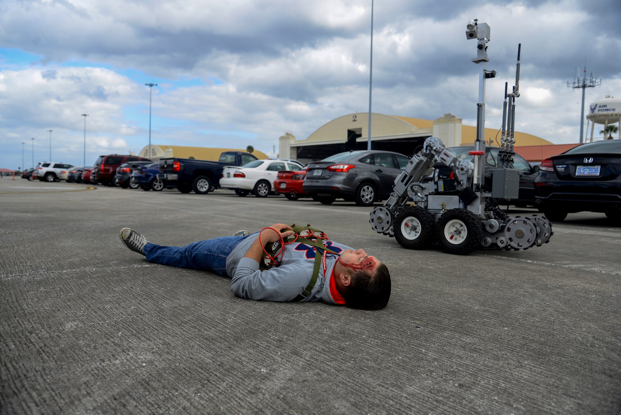 Senior Airman Taylor Lahteine, an explosive ordnance disposal (EOD) technician assigned to the 6th Civil Engineer Squadron, lays on the flightline as a simulated suicide bomber while an EOD robot assesses him during a major accident response exercise at MacDill Air Force Base, Fla., Feb. 9, 2016. Emergency response personnel conducted an active-shooter exercise to prepare for any mishaps that may occur during the Tampa Bay AirFest scheduled to take place March 19 and 20. (U.S. Air Force photo by Staff Sgt. Melanie Hutto) 
