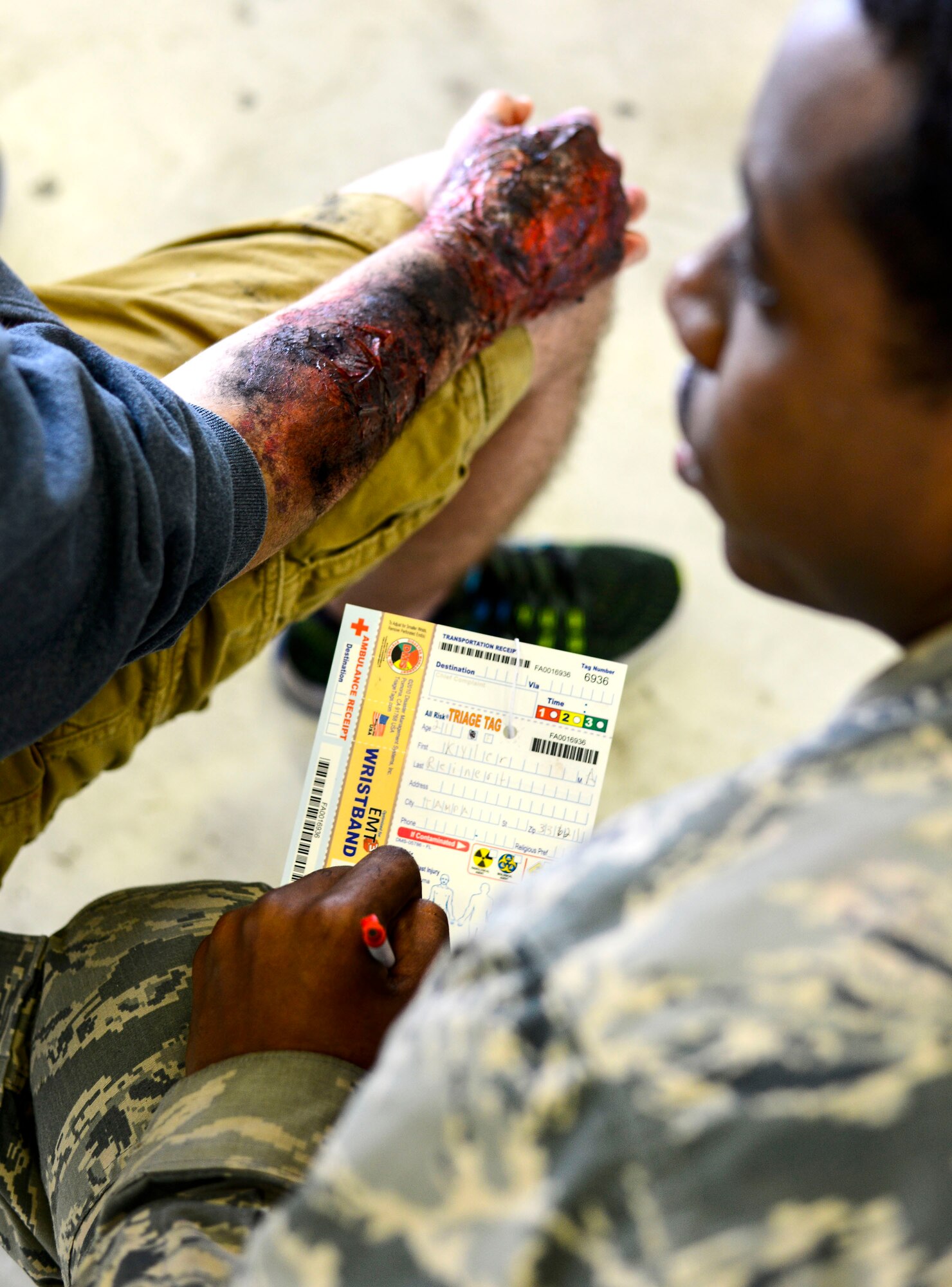 An Airman assigned to the 6th Medical Group fills out a triage card during a major accident response exercise (MARE) at MacDill Air Force Base, Fla., Feb. 8, 2016. A triage card is a tool first responders and medical personnel use during a mass casualty incident that provides a snapshot of a patient’s medical condition at time of initial triage and allows them to categorize their priority. (U.S. Air Force photo by Staff Sgt. Melanie Hutto) 
