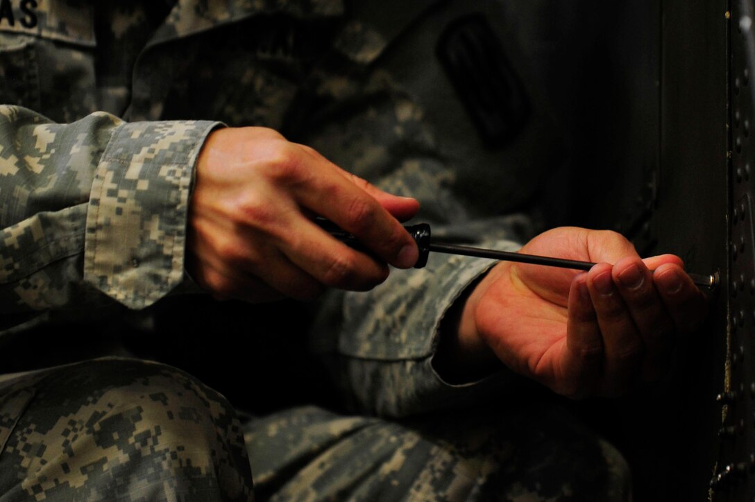 A U.S. Soldier from the 128th Aviation Brigade, 1st Battalion, 222nd Aviation Regiment, screws a panel shut on a Boeing AH-64 Apache during an armament, electronic and avionics systems repair course at Fort Eustis, Va., Feb. 11, 2016. Soldiers assigned to the brigade are first taught using computerized instruction manuals and touch screen simulators before transitioning to using operational Apaches as they progress during an armament, electronic and avionics systems repair course. (U.S. Air Force photo by Airman 1st Class Breonna Veal)