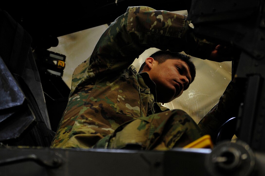 U.S. Army Spc. Jose Hernandez, a student with 128th Aviation Brigade, 1st Battalion, 222nd Aviation Regiment, performs maintenance on a Boeing AH-64 Apache during an armament, electronic and avionics systems repair course at Fort Eustis, Va., Feb. 11, 2016. The Soldiers are taught how to first replace the unusable aircraft pieces, then how to ensure the piece is working once placed back into the aircraft. (U.S. Air Force photo by Airman 1st Class Breonna Veal) 