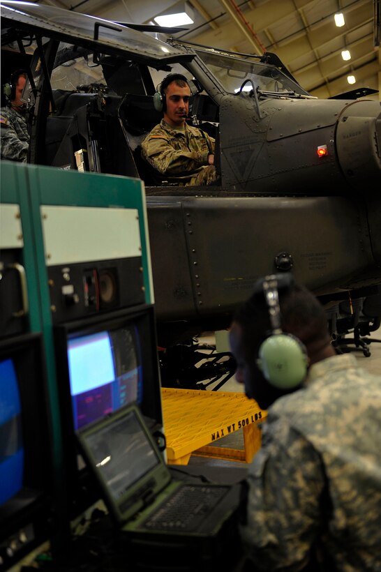 U.S. Army Pfc. Cedric Ebrottie, a student with 128th Aviation Brigade, 1st Battalion, 222nd Aviation Regiment, speaks with fellow student, Spc. Dominic Freitas, during an armament, electronic and avionics systems repair course at Fort Eustis, Va., Feb. 11, 2016. Students perform maintenance operation checks on a Boeing AH-64 Apache to troubleshoot aircraft components. (U.S. Air Force photo by Airman 1st Class Breonna Veal)