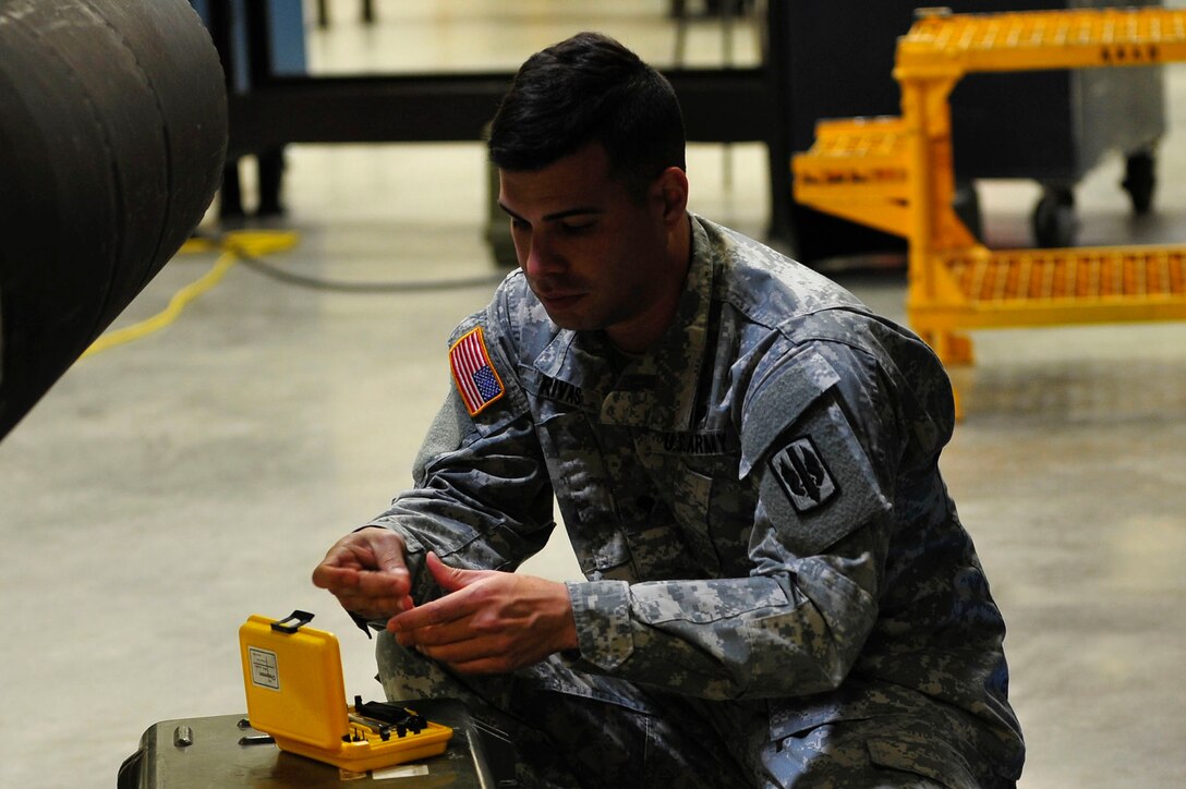 A U.S. Soldier from the 128th Aviation Brigade, 1st Battalion, 222nd Aviation Regiment looks for a tool during an armament, electronic and avionics systems repair course at Fort Eustis, Va., Feb. 11, 2016. Soldiers use the tools to remove specific electronic components on a Boeing AH-64 Apache. (U.S. Air Force photo by Airman 1st Class Breonna Veal)