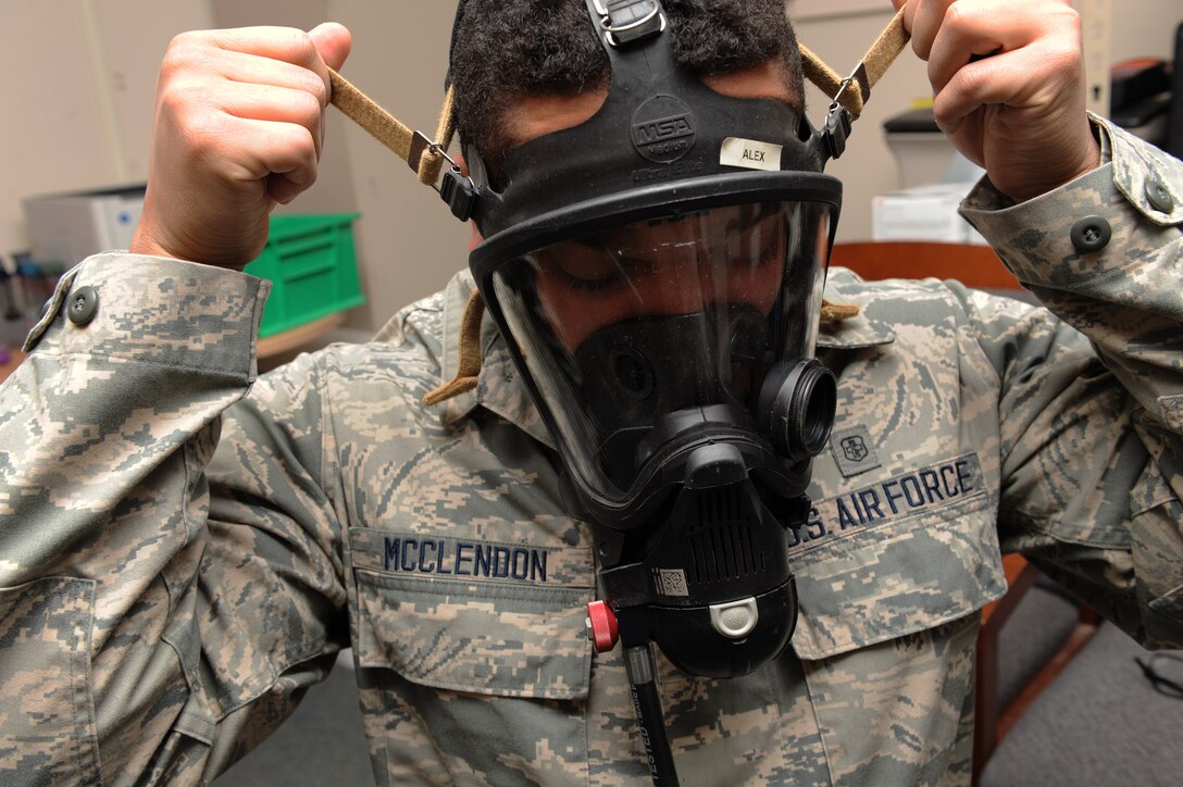 U.S Air Force Airman Alex McClendon, 633rd Aerospace Medicine Squadron bioenvironmental engineer technician, dons a Mine Safety Appliances FireHawk mask at Langley Air Force Base, Va., Feb. 9, 2016. Bioenvironmental Airmen use these masks when going on supplied air to respond to an emergency, such as entering contaminated areas. (U.S. Air Force photo by Senior Airman Brittany E. N. Murphy)