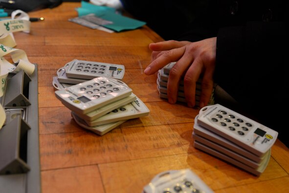 U.S. Air Force Staff Sgt. Sonia Toro-Valles, 100th Security Forces Squadron operations support staff NCO, stacks remote controls after the “#SaySomething: Bystander Intervention Initiative” training seminar Feb. 9, 2016 in the base theater on RAF Mildenhall, England. The remote controls were used for anonymous polling to help generate a genuine discussion about bystander intervention, help understand where ideas lie and what could be improved via instant feedback. (U.S. Air Force photo by Staff Sgt. Micaiah Anthony/Released)