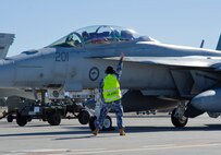 A Royal Australian Air Force member signals to two F/A-18F Super Hornet pilots during Red Flag 16-1, Feb. 2, 2016 at Nellis AFB, Nev. More than 30 squadrons at Red Flag 16-1 are working together as they would in the field bringing them all together, possibly for the first time, before facing an actual threat. (U.S. Air Force photo by Senior Airman Alex Fox Echols III/Released)  