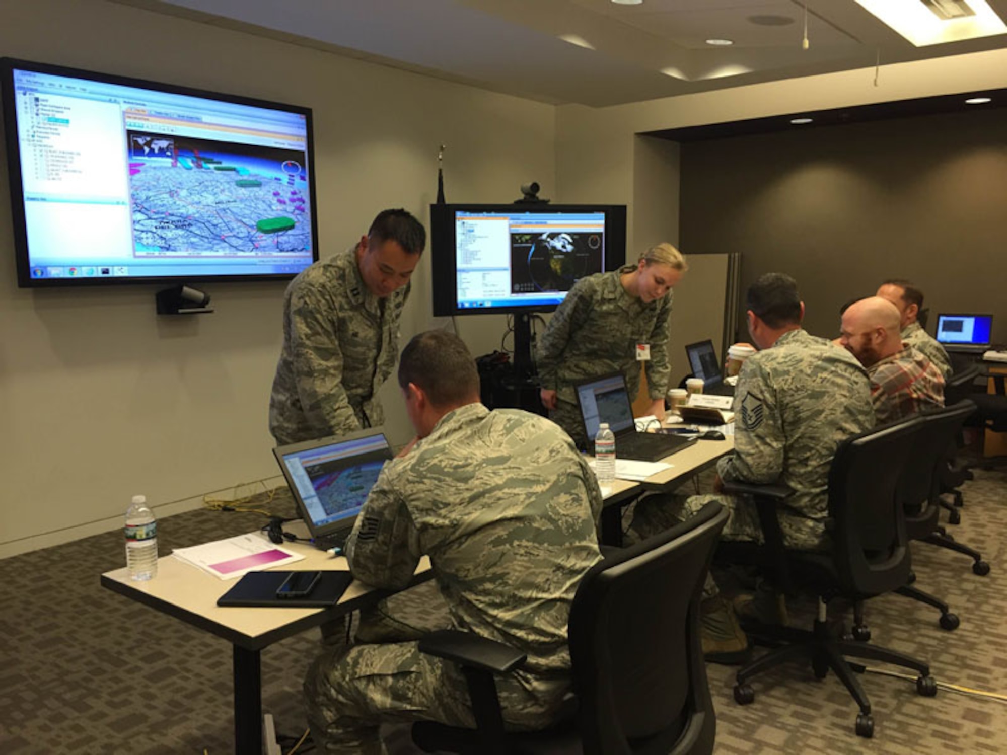 Capt. Jon Ng, previous Airspace Management Application - Airspace Information Services  program manager, and 2nd Lt. Erin Rost, current AMSA-ASIS PM, assist users and team members during a Warfighter Assessment in Reston, Va., with a draft version of the AMSA-ASIS system in May 2015. The AMSA-ASIS system is one piece of the Command and Control Air Operations Suite-C2 Information Services program, managed out of Hanscom Air Force Base, Mass., which will improve flexibility of C2 applications and information services for the warfighter. (Courtesy photo)

