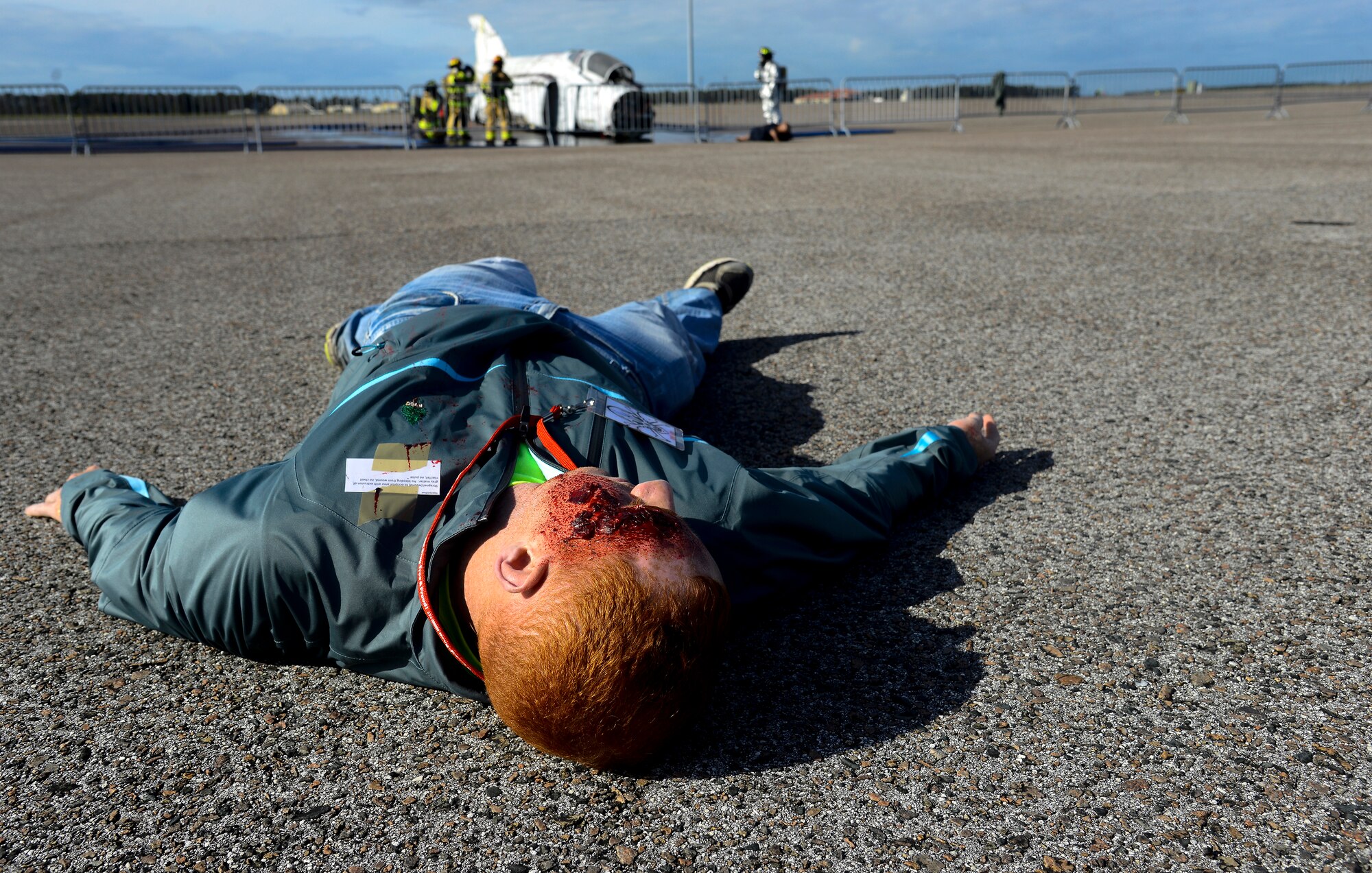 A simulated casualty lays on the flightline after a plane crash during a major accident response exercise (MARE) at MacDill Air Force Base, Fla., Feb. 8, 2016. Volunteers from around MacDill were covered with fake wounds to simulate casualties during the MARE. (U.S. Air Force photo by Staff Sgt. Melanie Hutto) 