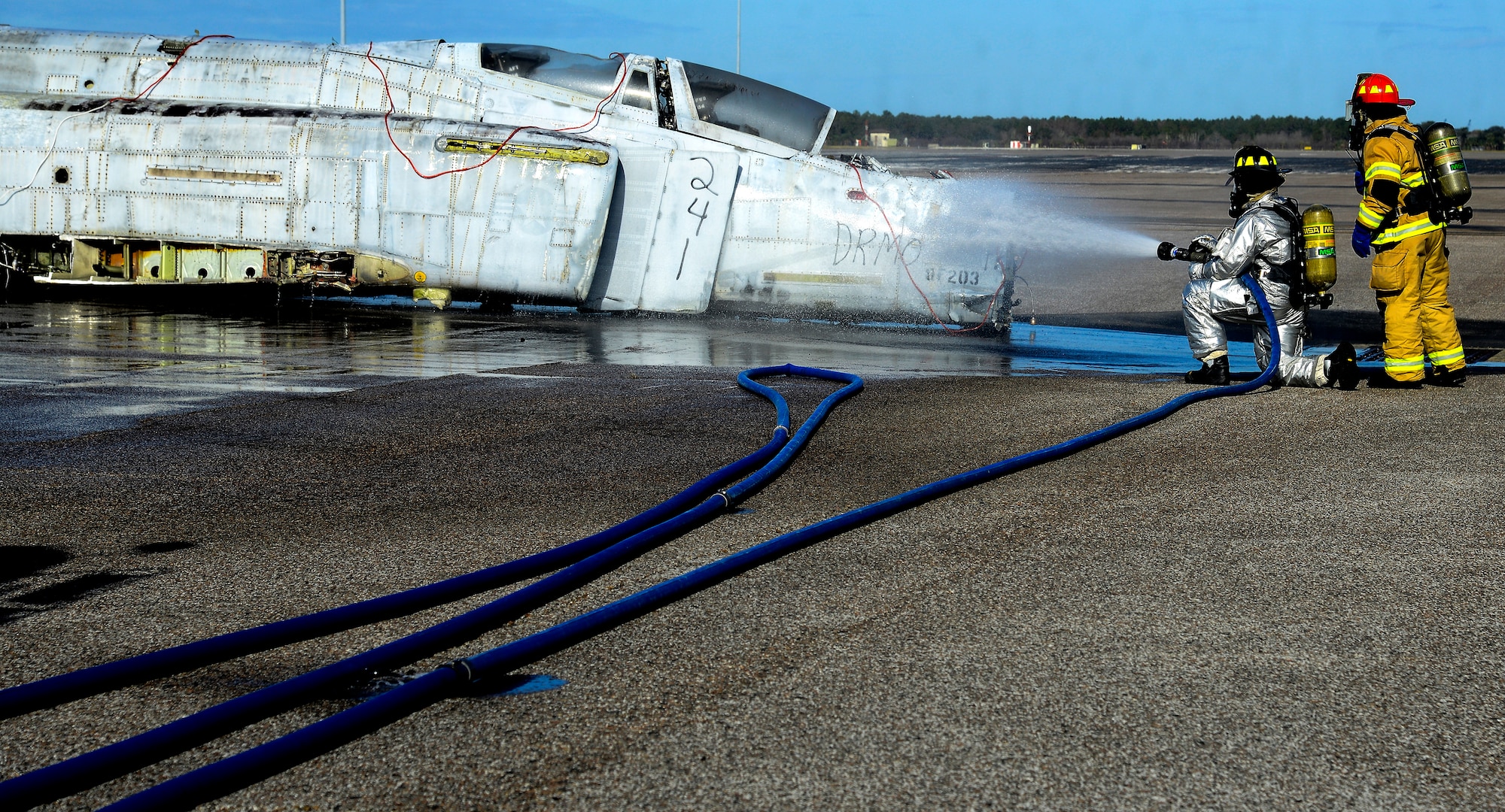 Two firefighters assigned to the 6th Civil Engineer Squadron spray an aircraft at the scene of a simulated aircraft crash during a major accident response exercise (MARE) at MacDill Air Force Base, Fla., Feb. 8, 2016. Firefighters and other emergency response personnel conducted the MARE to prepare for any mishaps that may occur during the Tampa Bay AirFest scheduled to take place March 19 and 20. (U.S. Air Force photo by Staff Sgt. Melanie Hutto)