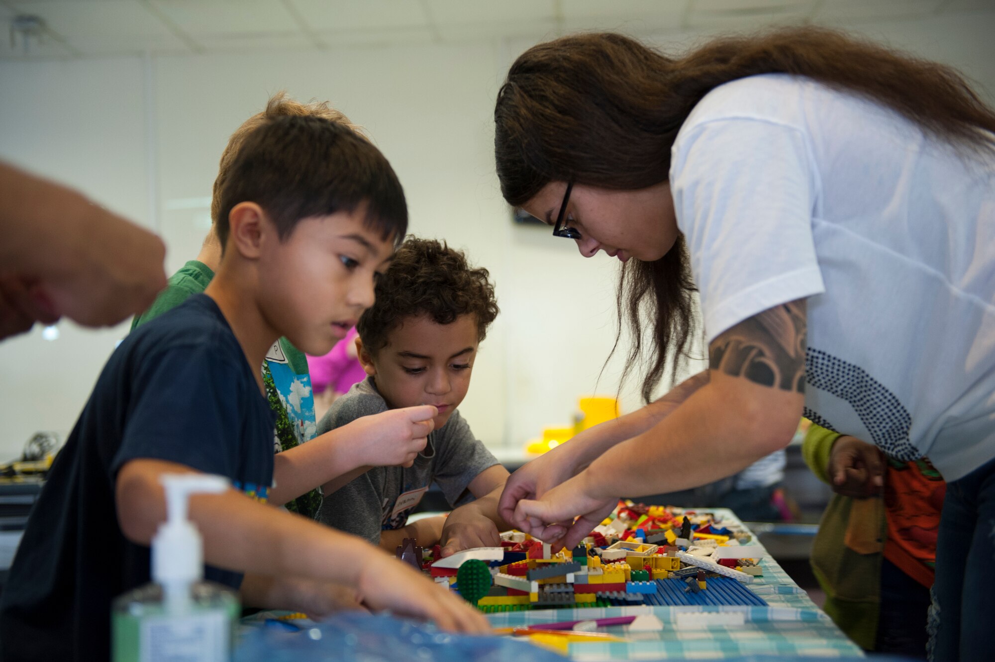 U.S. Air Force Airman 1st Class Angelica Torres, 18th LRS material management journeyman, coaches one of the contestants during the Lego Master Builder Challenge, Feb. 13, 2016, at Kadena Air Base, Japan. The coaches were volunteer active duty Air Force service members that came to help keep the children focused, solve problems and to peak their interest in science, technology, engineering and math. (U.S. Air Force photo by Airman Zackary A. Henry)