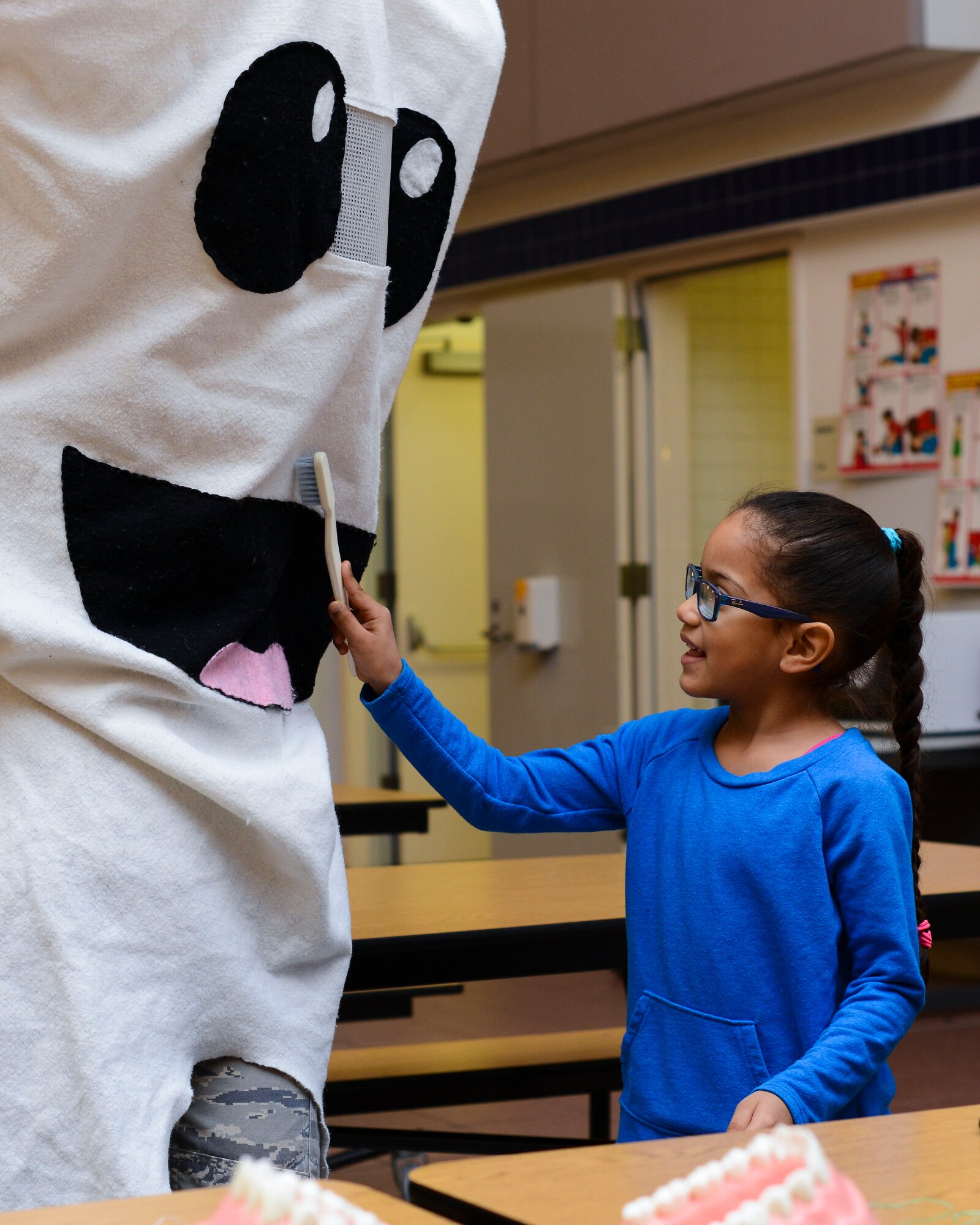 Rhya Washington, Aviano Elementary School kindergartner, brushes a giant tooth during a National Children’s Dental Health Month event, Feb. 16, 2016, at Aviano Air Base, Italy. Airmen from the 31st Dental Squadron visited Aviano Elementary School to teach children good oral hygiene. (U.S. Air Force photo by Senior Airman Austin Harvill/Released)