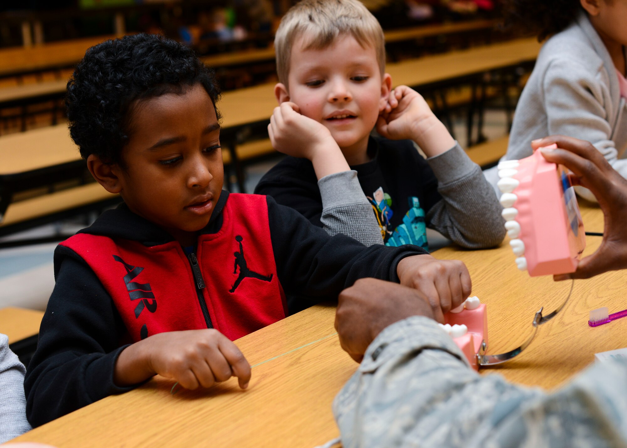 Maximus Burr, Aviano Elementary School kindergartner, practices flossing during a National Children’s Dental Health Month event, Feb. 16, 2016, at Aviano Air Base, Italy. Airmen from the 31st Dental Squadron visited Aviano Elementary School to teach children good oral hygiene. (U.S. Air Force photo by Senior Airman Austin Harvill/Released)