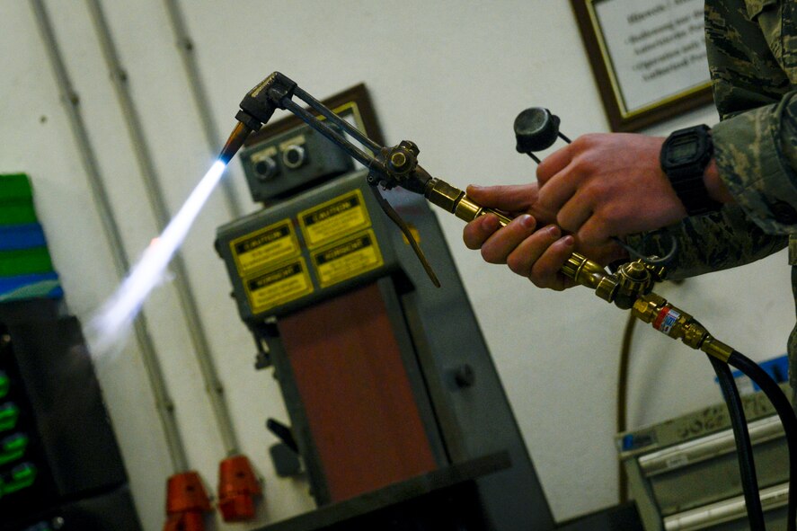 Airman 1st Class Ty Pocha, 786th Civil Engineer Squadron heavy repair and construction flight structural journeyman, holds a torch before a metal shaping demonstration Feb. 12, 2016, at Ramstein Air Base, Germany. Students from the Ramstein Intermediate School took a tour of the 786th CES, observed machinery, and learned how Airmen do their jobs and fix things in the community. (U.S. Air Force photo/Senior Airman Nicole Sikorski) 