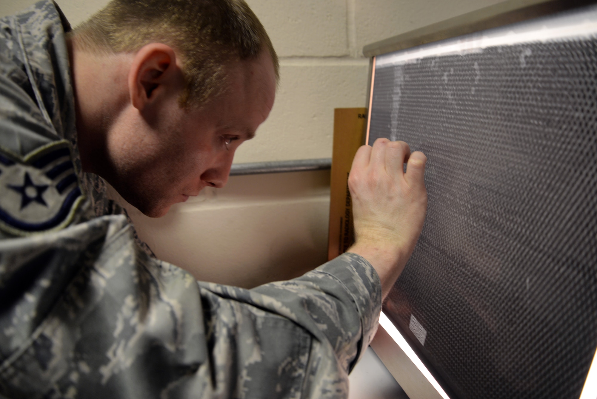 U.S. Air Force Staff Sgt. Joel Kelehar, 100th Maintenance Squadron non-destructive inspection craftsman, inspects a honeycomb panel for damage and water intrusion Feb. 3, 2016, on RAF Mildenhall, England. NDI ensure aircraft parts are fixed right away to prevent any further damage. (U.S. Air Force photo by Senior Airman Christine Halan/Released)