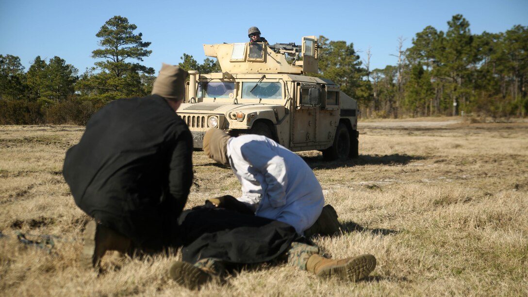 Marines role-playing as the enemy cover a notionally-injured comrade during a convoy operations exercise with Combat Logistics Battalion 6 at Marine Corps Base Camp Lejeune, N.C., Feb. 11, 2016. The mission of the convoy was to recover a downed vehicle and eliminate potential hostile enemies along their route.