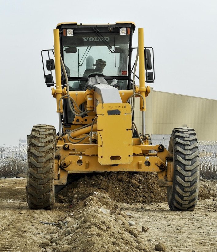 Air Force Senior Airman Xavier Newton operates a road grader to level out dirt and gravel while building the foundation for a new road on Bagram Airfield, Afghanistan, Feb. 9, 2016. Newton is assigned to the 455th Expeditionary Civil Engineers Squadron. Air Force photo by Tech. Sgt. Nicholas Rau