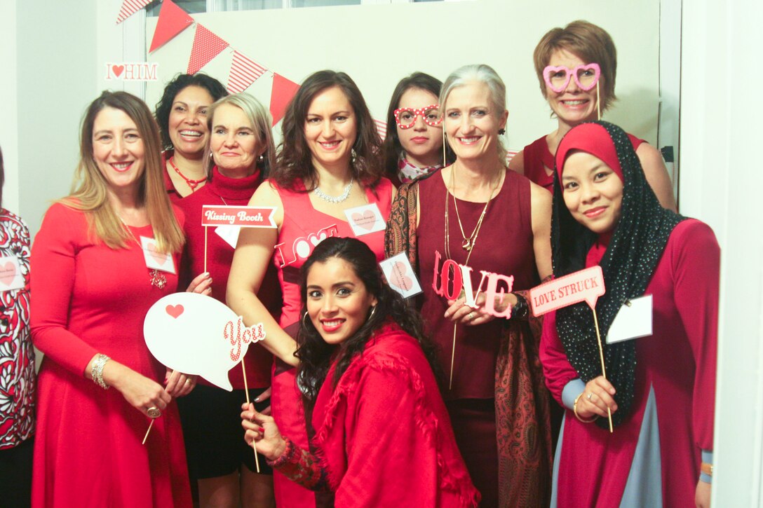 The wives of international officers attending Marine Corps University pose at the Quantico Officers Spouses Organization Red Dress Gala in support of heart health awareness Feb. 5.